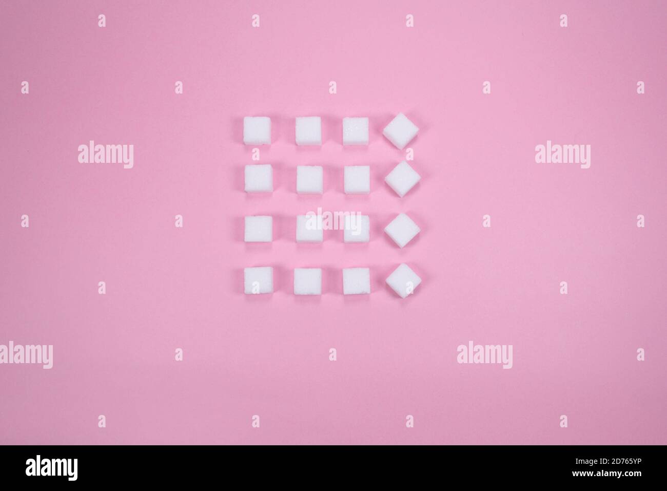 Weiße Zuckerwürfel auf rosa Hintergrund Zusammensetzung. Stockfoto