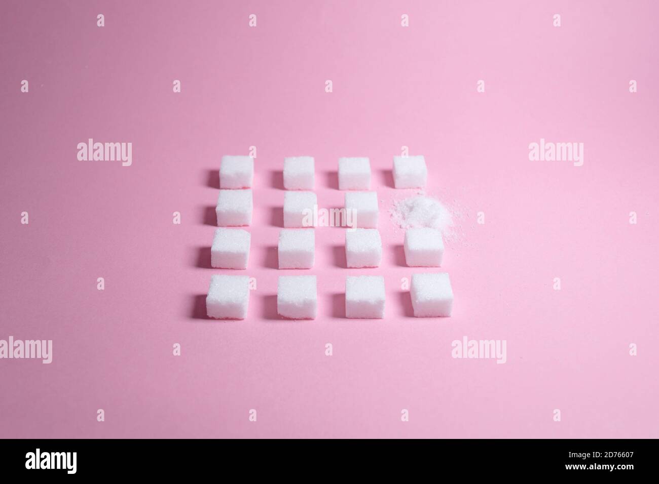 Weiße Zuckerwürfel auf rosa Hintergrund Zusammensetzung. Stockfoto