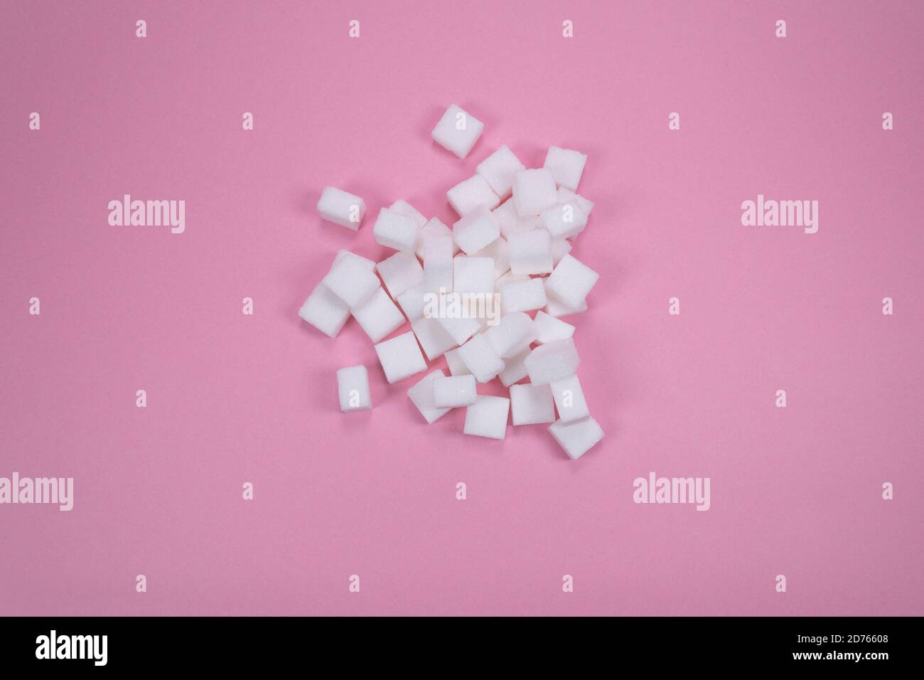 Weiße Zuckerwürfel auf rosa Hintergrund Zusammensetzung. Stockfoto
