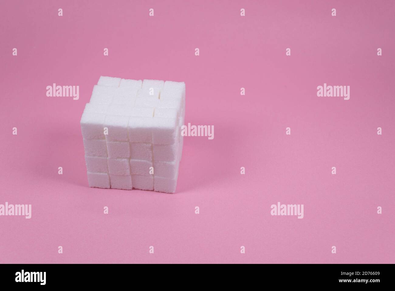 Weiße Zuckerwürfel auf rosa Hintergrund Zusammensetzung. Stockfoto