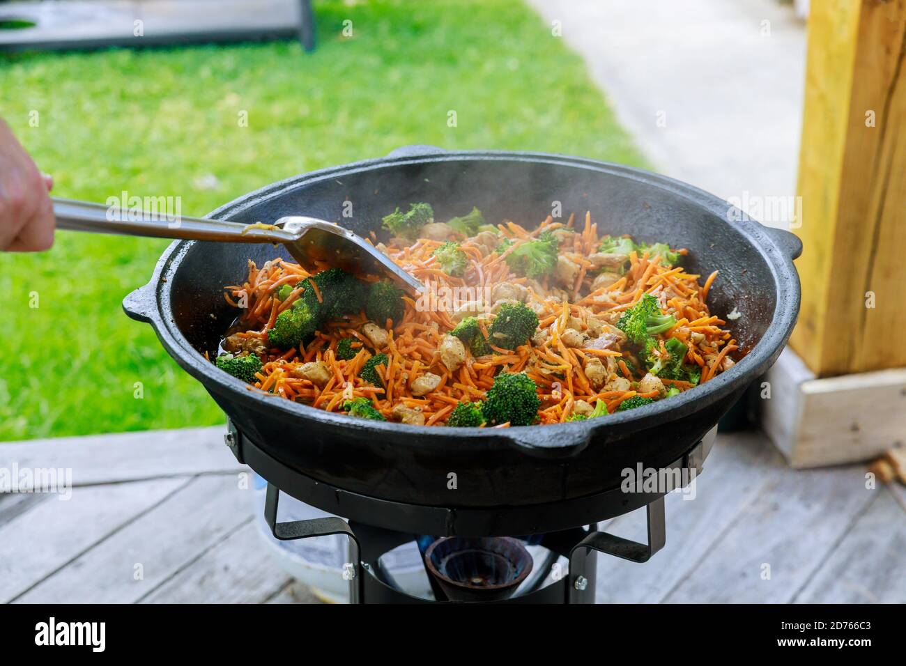 Prozess des Kochens von gesundem Gemüse in einem Kessel über Feuer draußen. Stockfoto