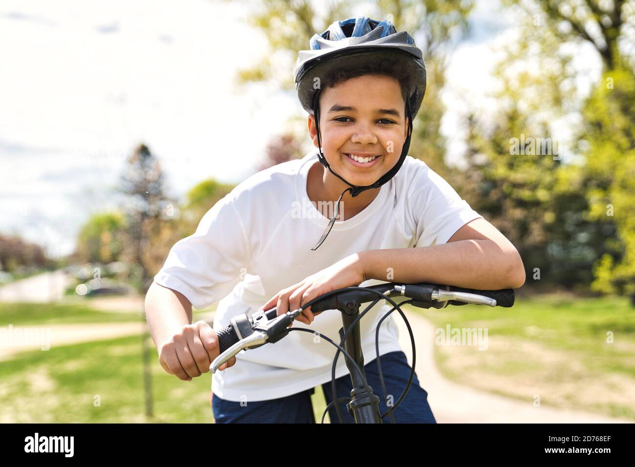 Boy Reiten Fahrrad trägt einen Helm draußen Stockfoto