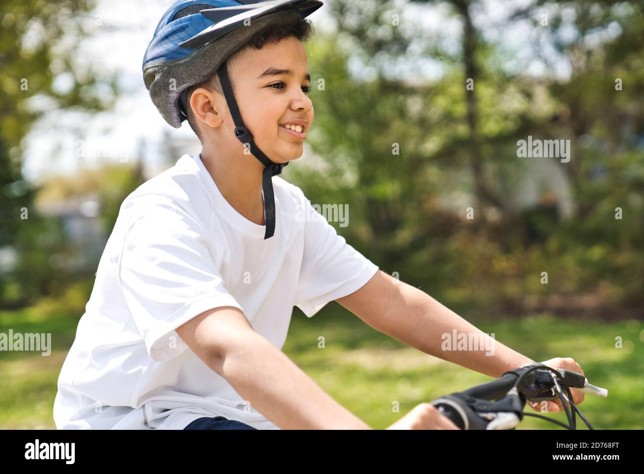 Boy Reiten Fahrrad trägt einen Helm draußen Stockfoto