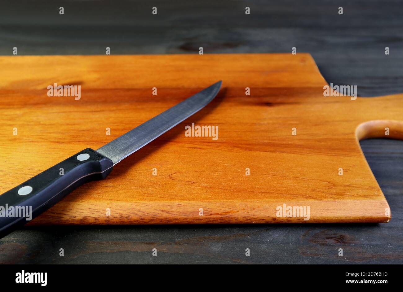 Küchenmesser isoliert auf einem Schneidebrett für das Konzept HAUSMANNSKOST Stockfoto