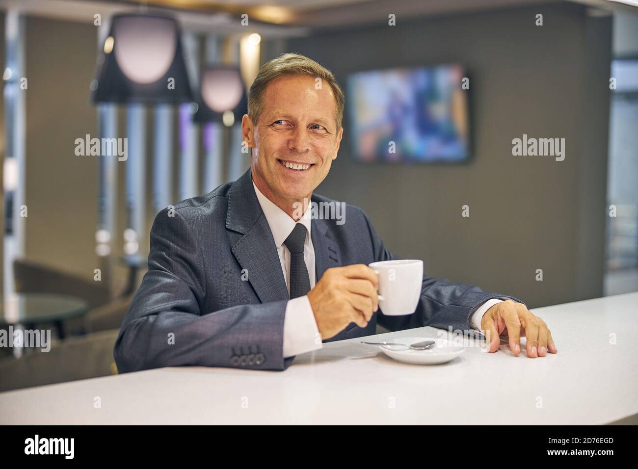 Freudig reifen eleganten Mann genießen heißen Drink Stockfoto
