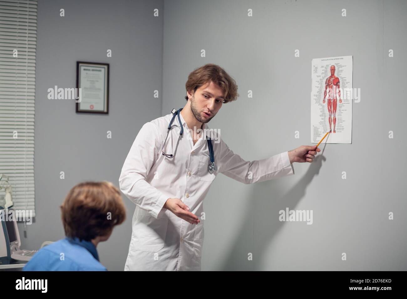 Ein junger Arzt erklärt seinem Patienten die Diagnose. Stockfoto