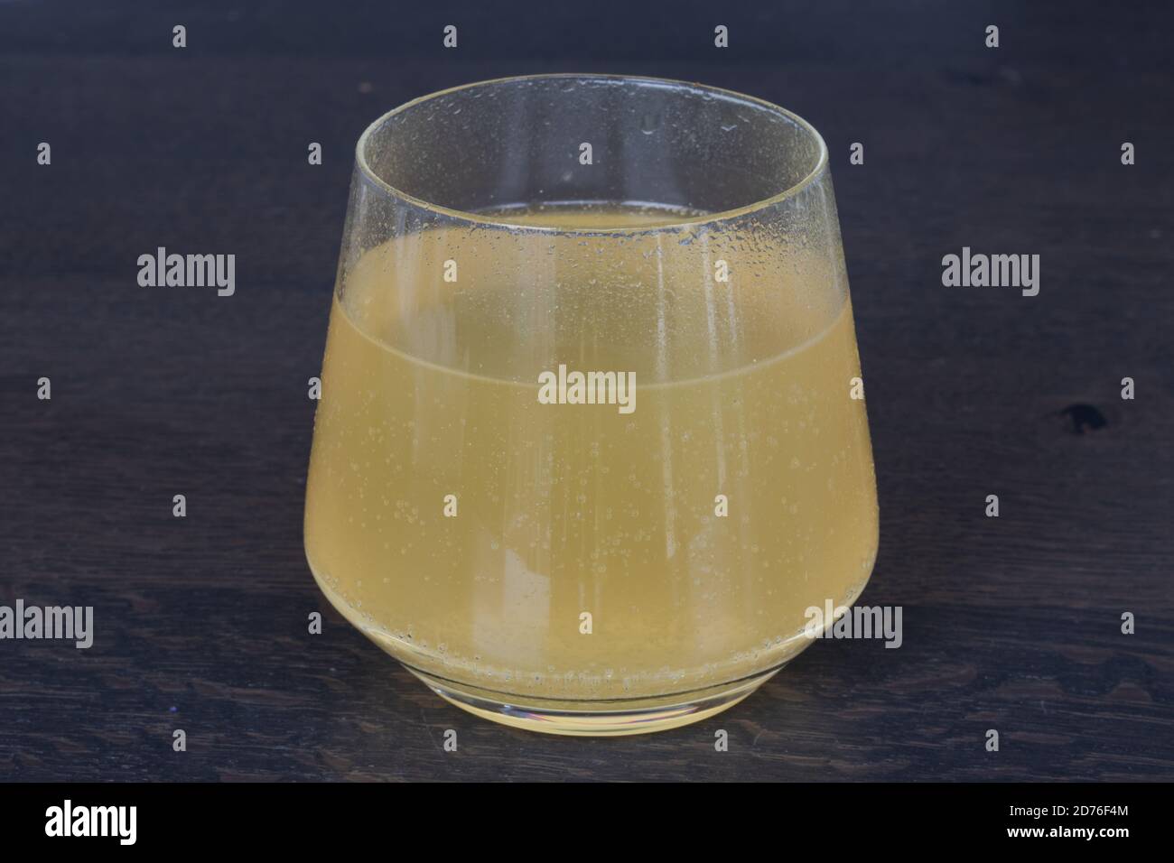 Transparentes Glas auf einer Holzoberfläche mit Vitamin C Brausetablette, Orangengeschmack Stockfoto