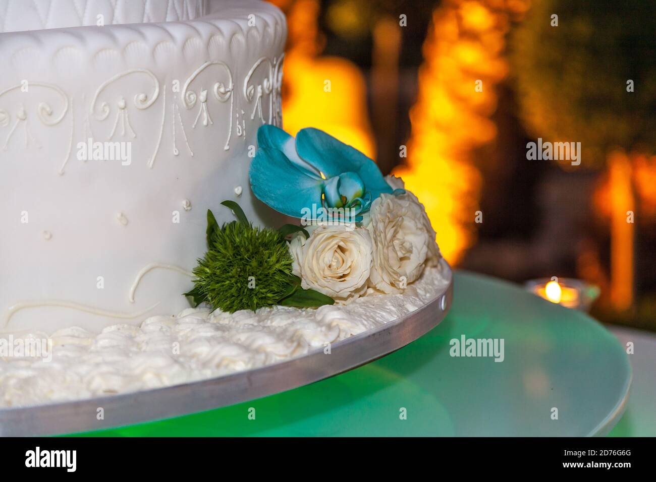 Dekoration einer Hochzeitstorte mit weißen Rosen und bunten Blumen, Hochzeitsfeier. Stockfoto