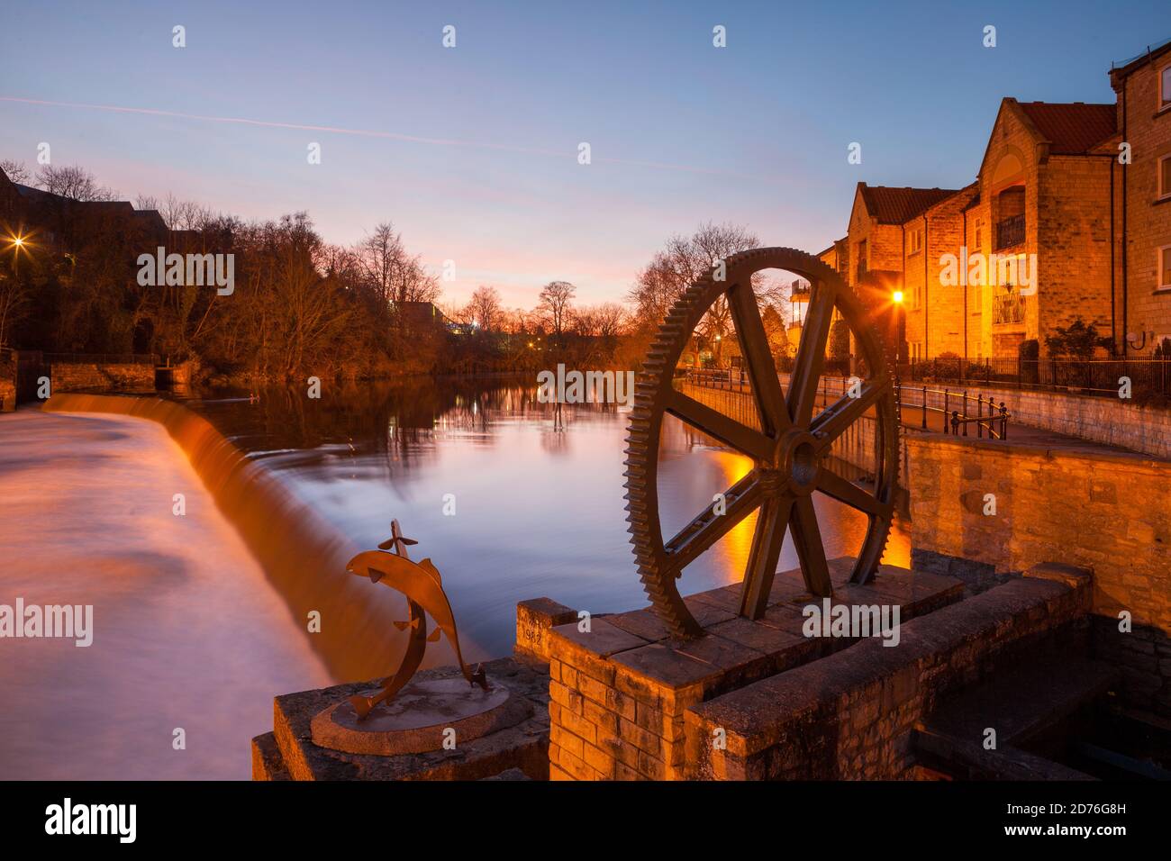 Abends Blick auf das Wehr über den Fluss Wharfe Wetherby in West Yorkshire mit einem alten Zahnrad Am Flussufer Stockfoto