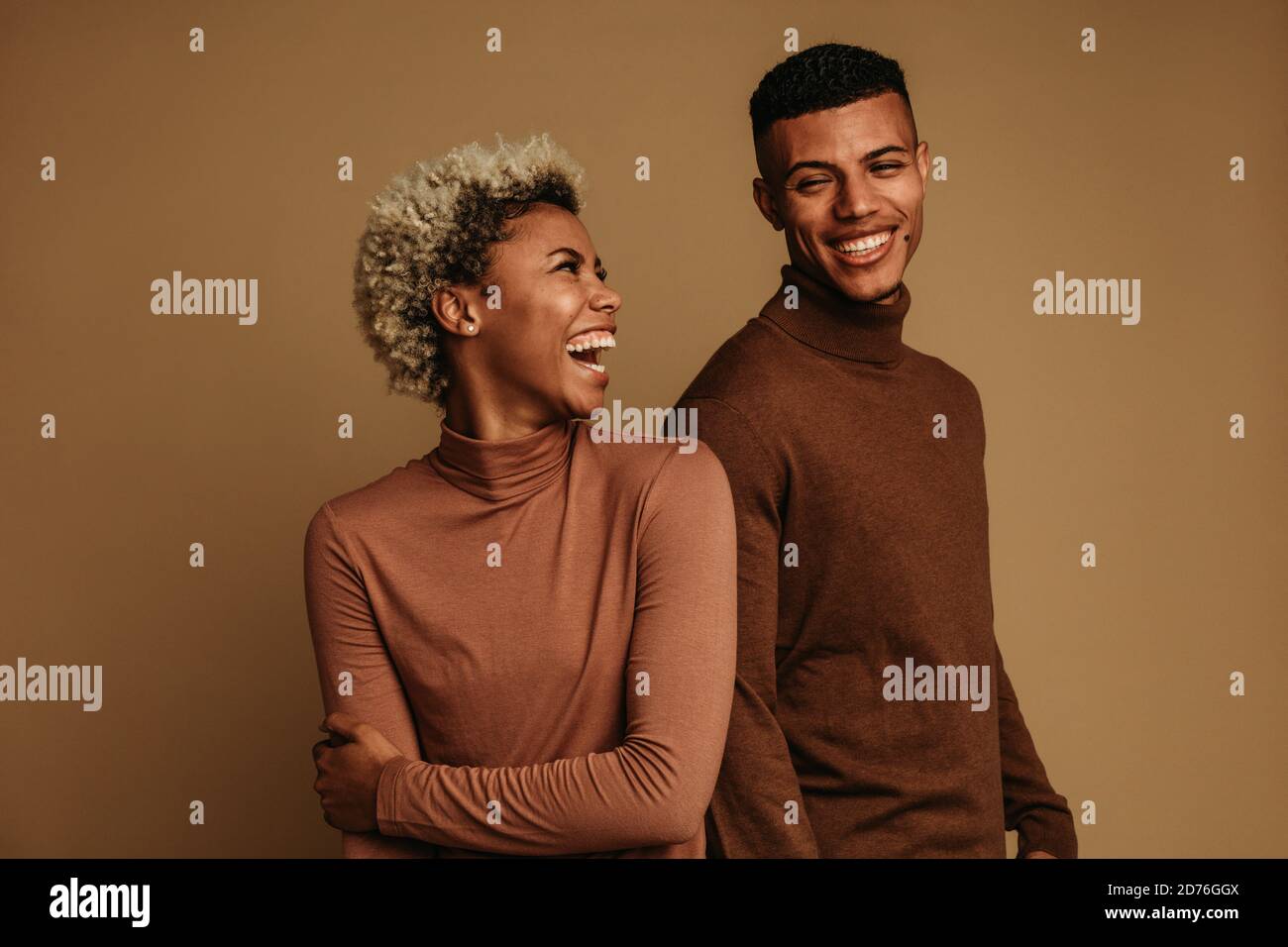 Fröhliches afroamerikanisches Paar in Winterkleidung. Pärchen schauten sich an und lachten. Stockfoto