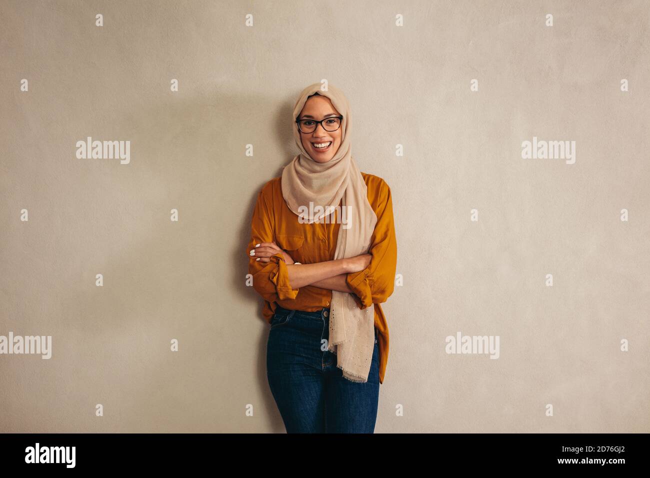 Portriat einer muslimischen Geschäftsfrau stehend mit ihren Amrs gekreuzt. Weibliche Unternehmerin, die sich an eine Wand lehnt. Stockfoto Portriat einer muslimischen Geschäftsfrau stehend mit ihren Amrs gekreuzt. Weibliche Unternehmerin, die sich an eine Wand lehnt. Stockfoto
