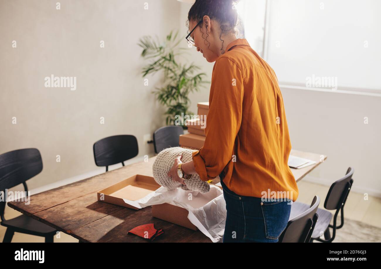 Drop Versand Geschäft Eigentümer Verpackung Paket für Online-Lieferung an den Kunden. Frau, die im Home Office arbeitet und einen Lieferkarton verpackt. Stockfoto
