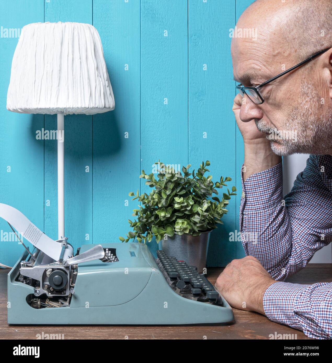 Ein Mann mittleren Alters schreibt mit einer alten Schreibmaschine Stockfoto