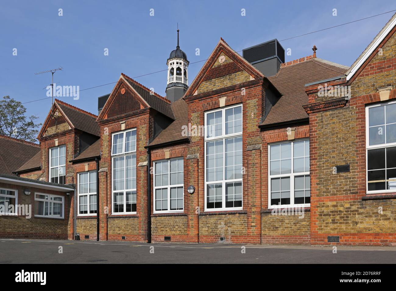 Neu renoviertes viktorianisches Schulgebäude in Dartford, Kent, Großbritannien. Zeigt den traditionellen Schulglockenturm und neue Lüftungsgeräte auf dem Dach. Stockfoto