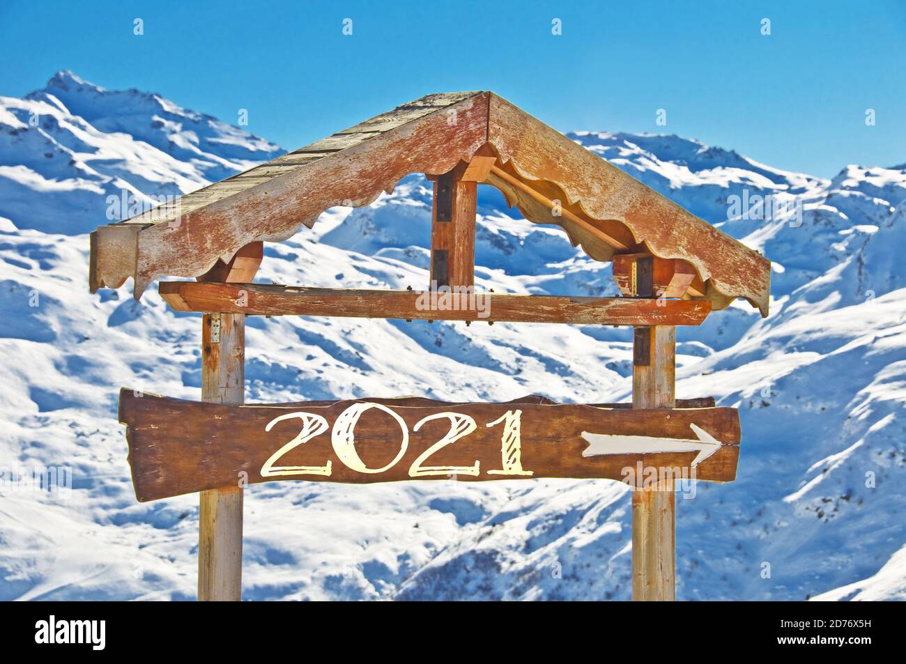 2021 geschrieben auf einem hölzernen Richtungsschild, blauer Himmel und Winter schneebedeckten Baumlandschaft Hintergrund frohe Feiertage Jahreszeiten Neujahr Grüße Stockfoto