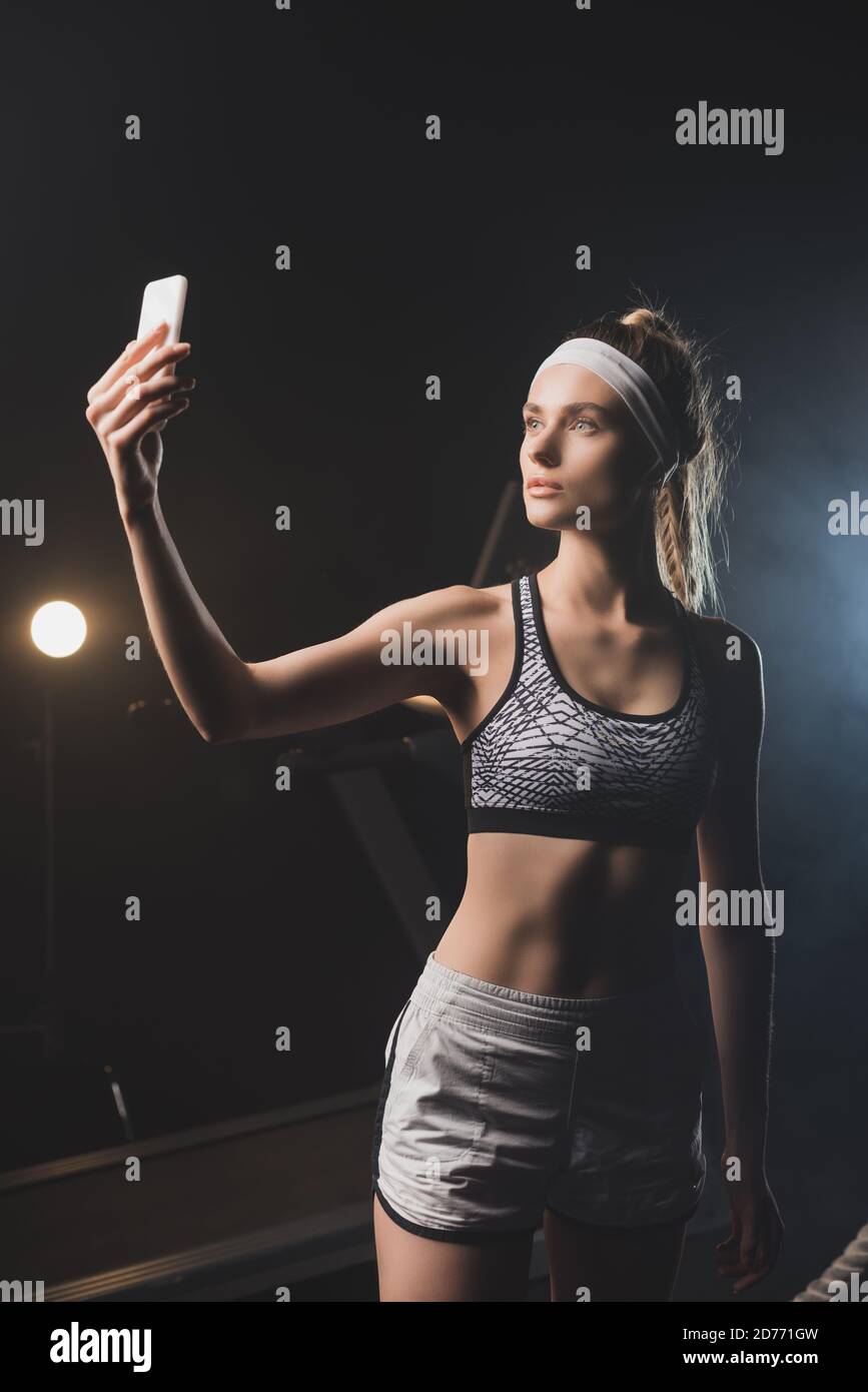 Vorderansicht der Sportlerin beim Selfie im Fitnessstudio Stockfoto
