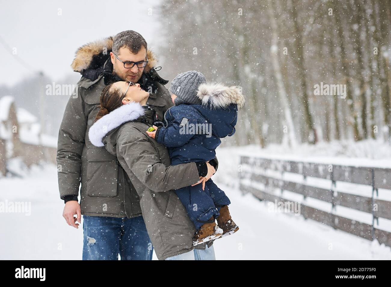 Glückliche Familie haben einen Spaß draußen in der Nähe des Hauses in Winter Stockfoto