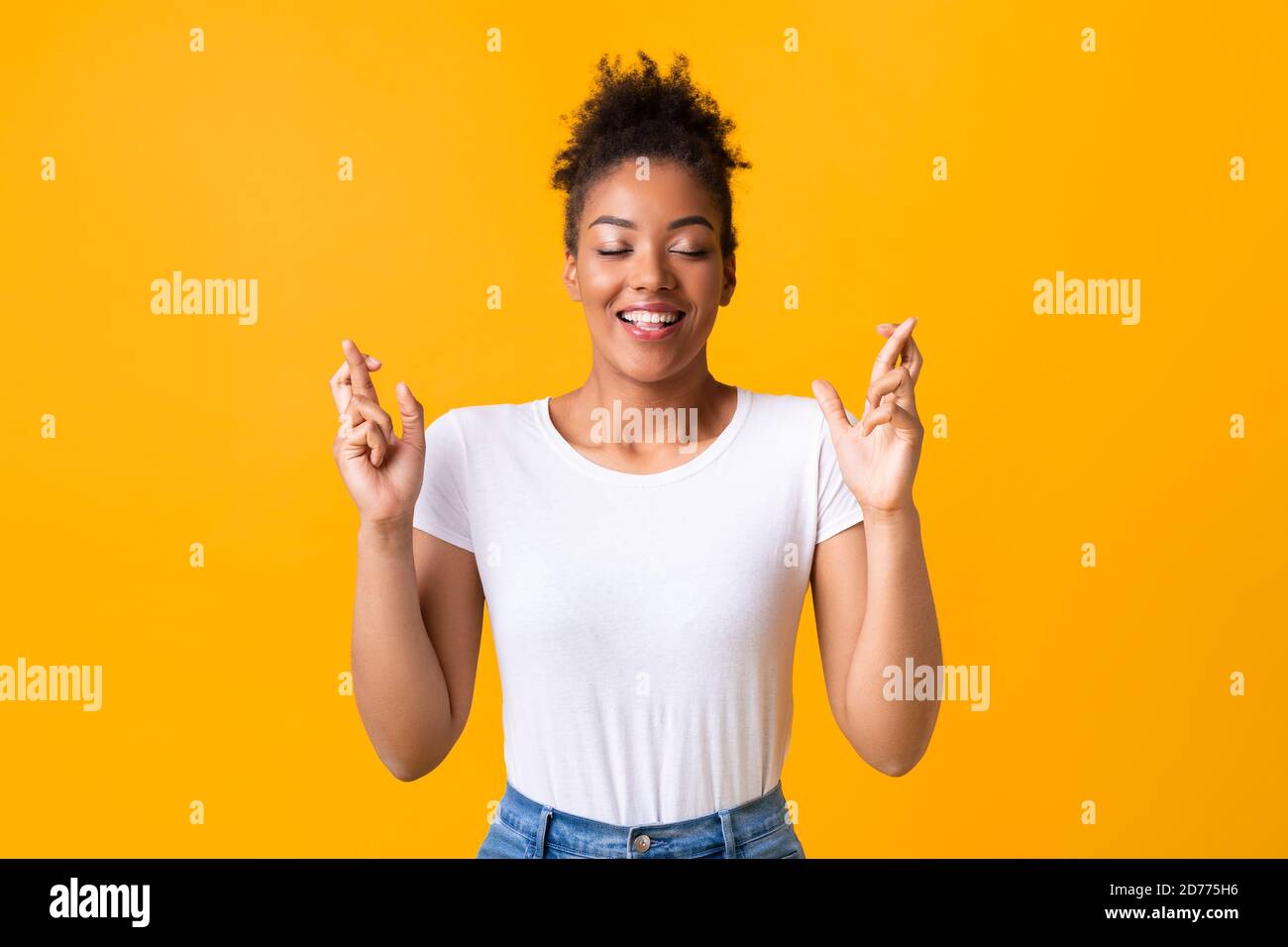Hoffnungsvolle afroamerikanische Dame, die ihre Finger kreuzt Stockfoto