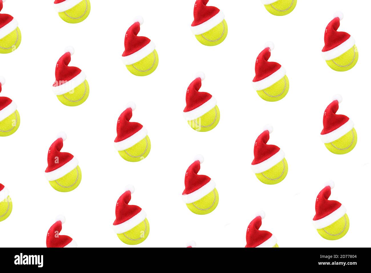 Weihnachtsmütze auf Tennisball Muster auf weißem Schnee Hintergrund. Frohe Weihnachten und Neujahrskonzept mit Tennisbällen. Gelb grüne Farbe Tennisbälle, Sport Lifestyle. Isoliert, Stockfoto