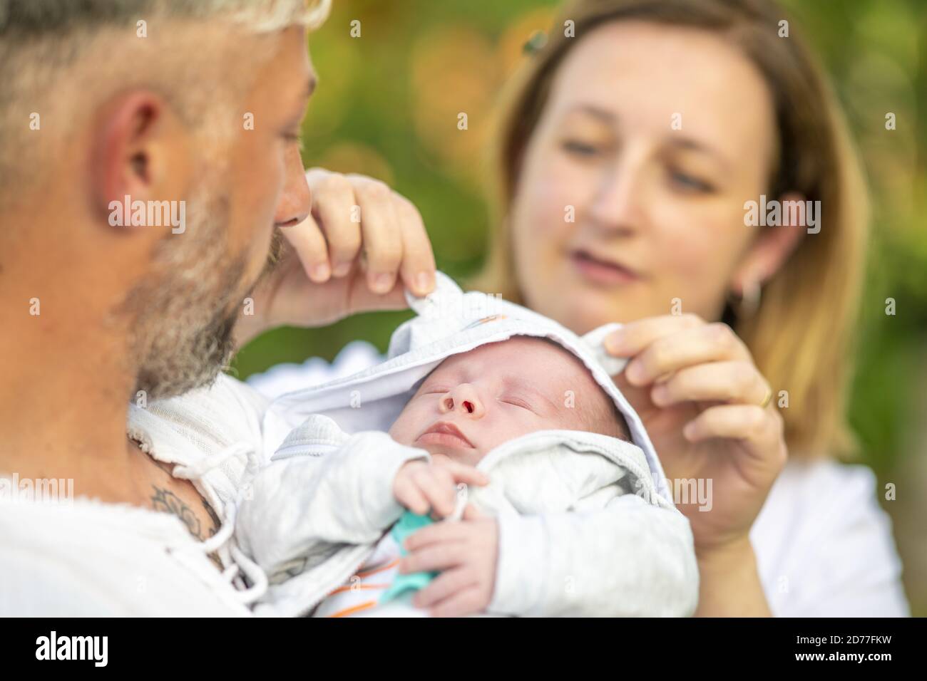 Neugeborenes Baby mit seinen Eltern im Freien. Stockfoto
