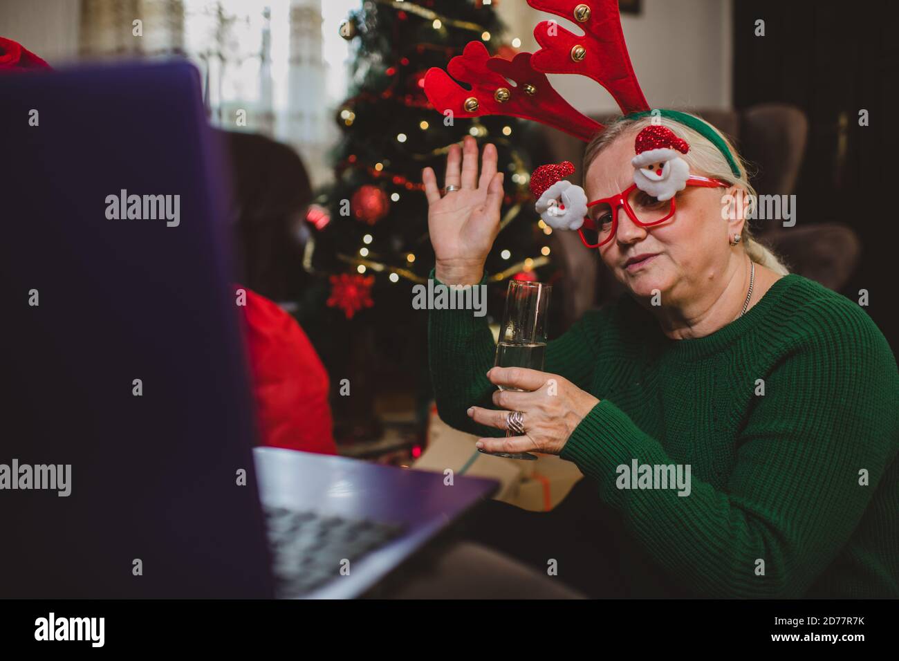 Ältere Frau zu Hause mit einer Weihnachtsfeier auf einem Videoanruf Stockfoto