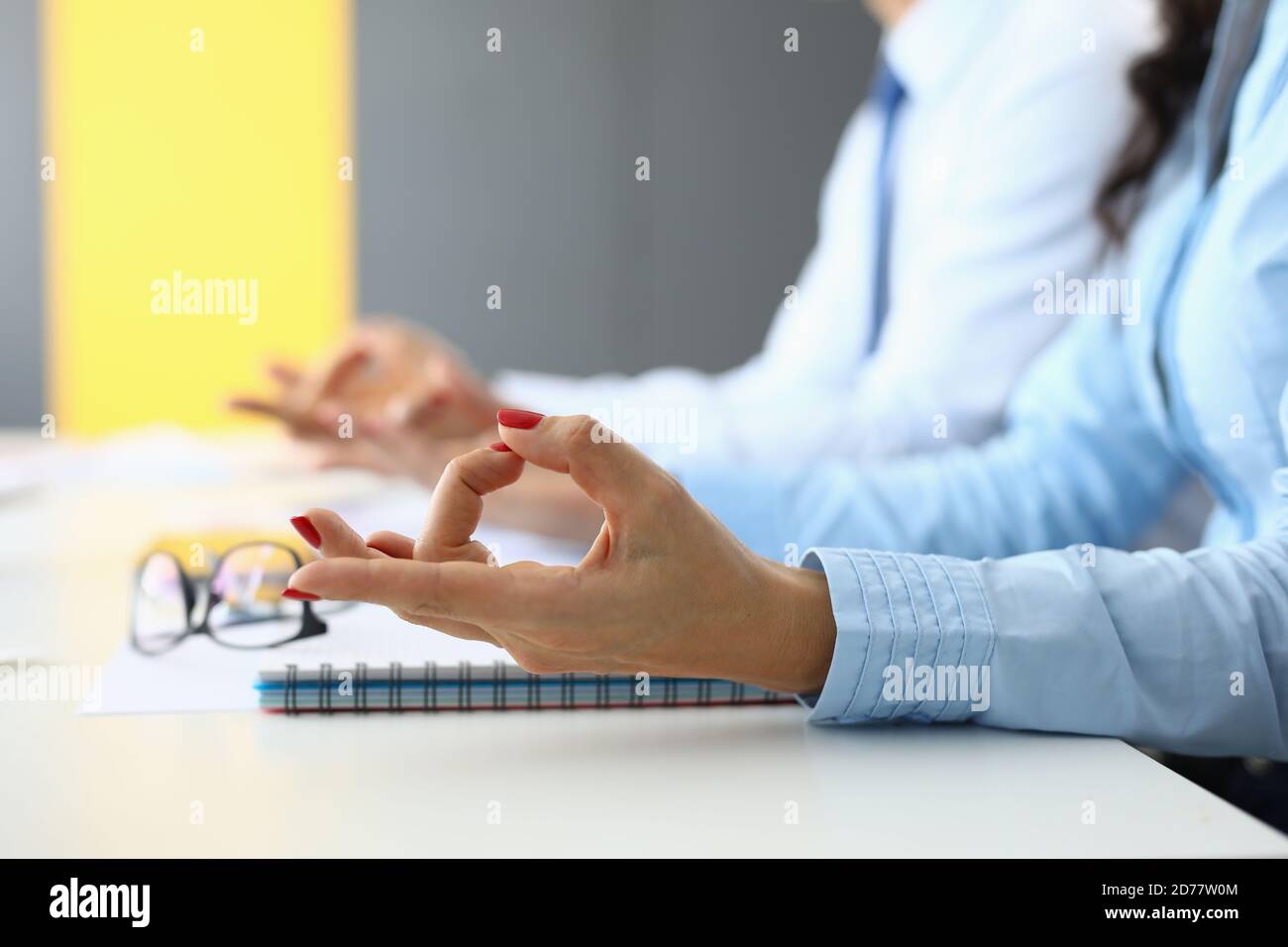 Weibliche und männliche Hände sind in Yoga-Fingern für die Meditation am Tisch im Büro verbunden. Stockfoto