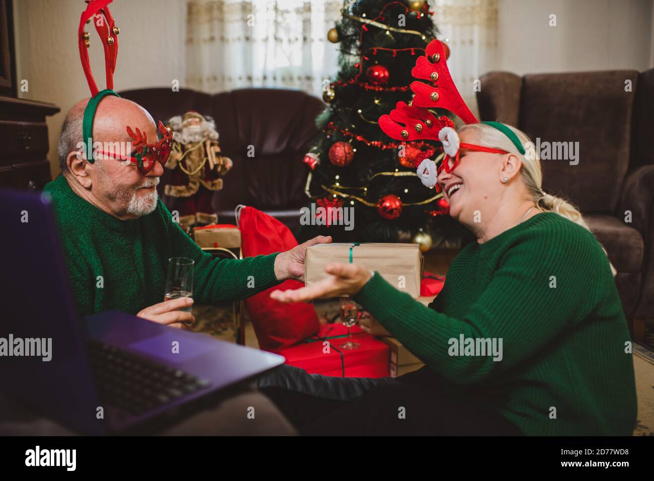 Seniorenpaar zu Hause mit einer Weihnachtsfeier auf einem Videoanruf Stockfoto