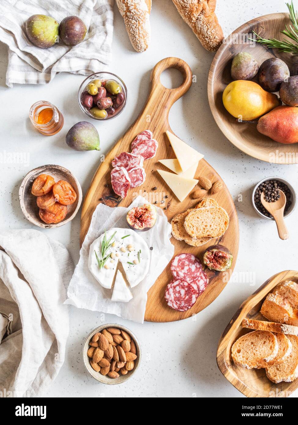 Snack-Set-Tisch. Vielfalt an Käse, Oliven, Wurst, Baguette Scheiben, Feigen, Nüsse auf Holzbrett grauen Hintergrund, Flat Lay. Draufsicht. Stockfoto