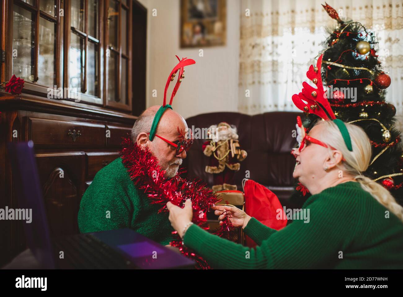 Seniorenpaar zu Hause mit einer Weihnachtsfeier auf einem Videoanruf Stockfoto