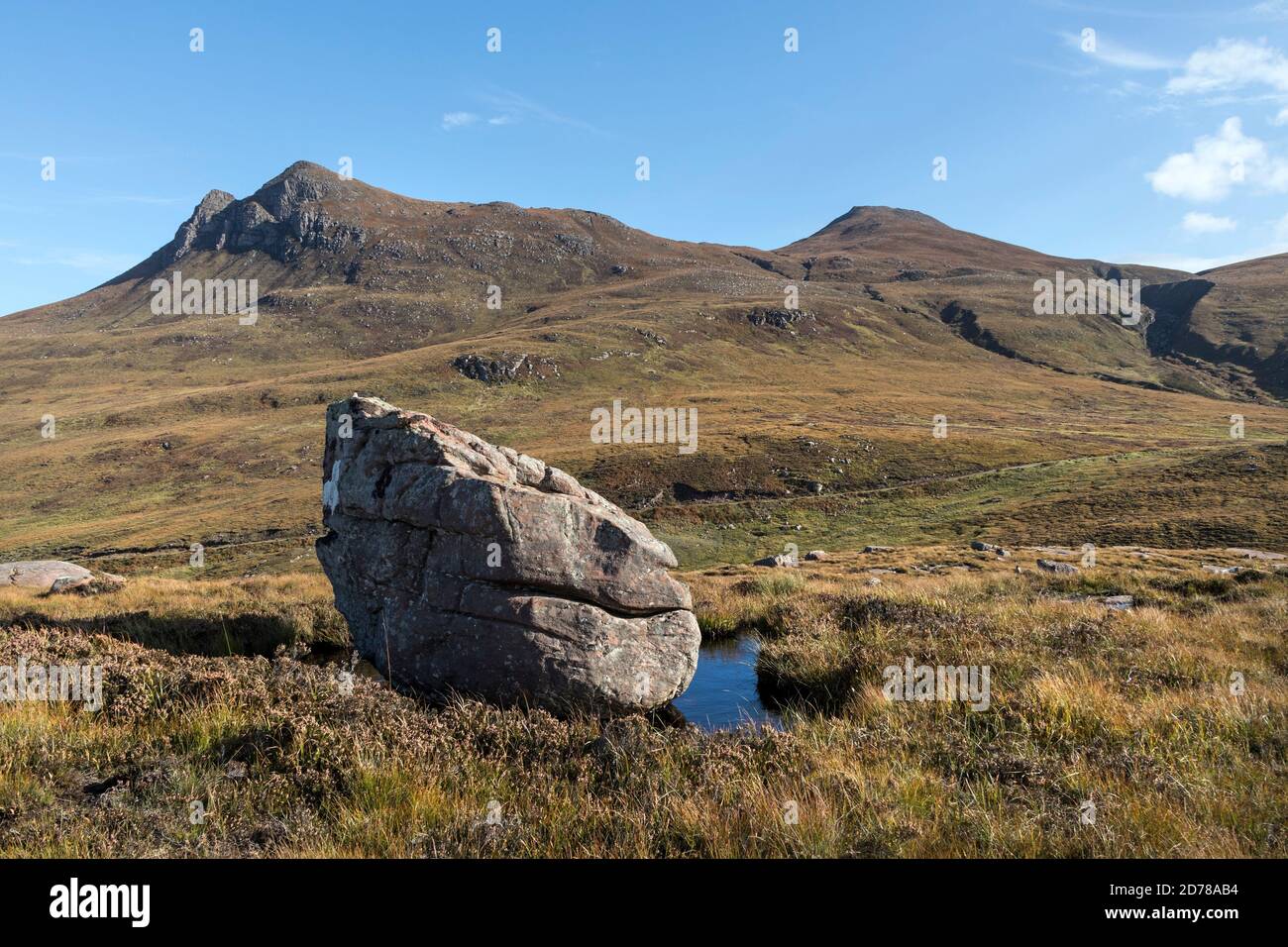 Erratischer Felsblock mit den Bergen Cairn Conmheall und Beinn nan Caorach, Coigach Peninsula, Wester Ross, Northwest Highlands of Scotland, Großbritannien Stockfoto