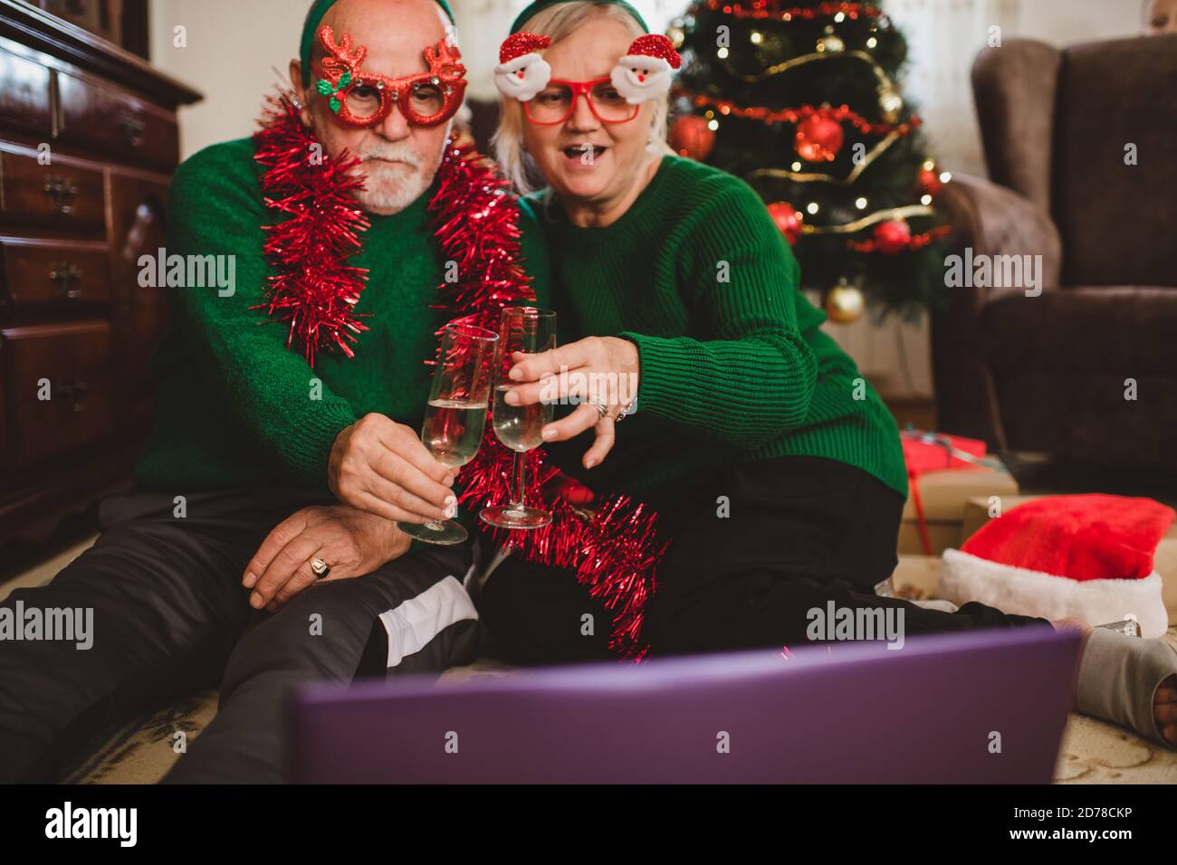 Seniorenpaar zu Hause mit einer Weihnachtsfeier auf einem Videoanruf Stockfoto