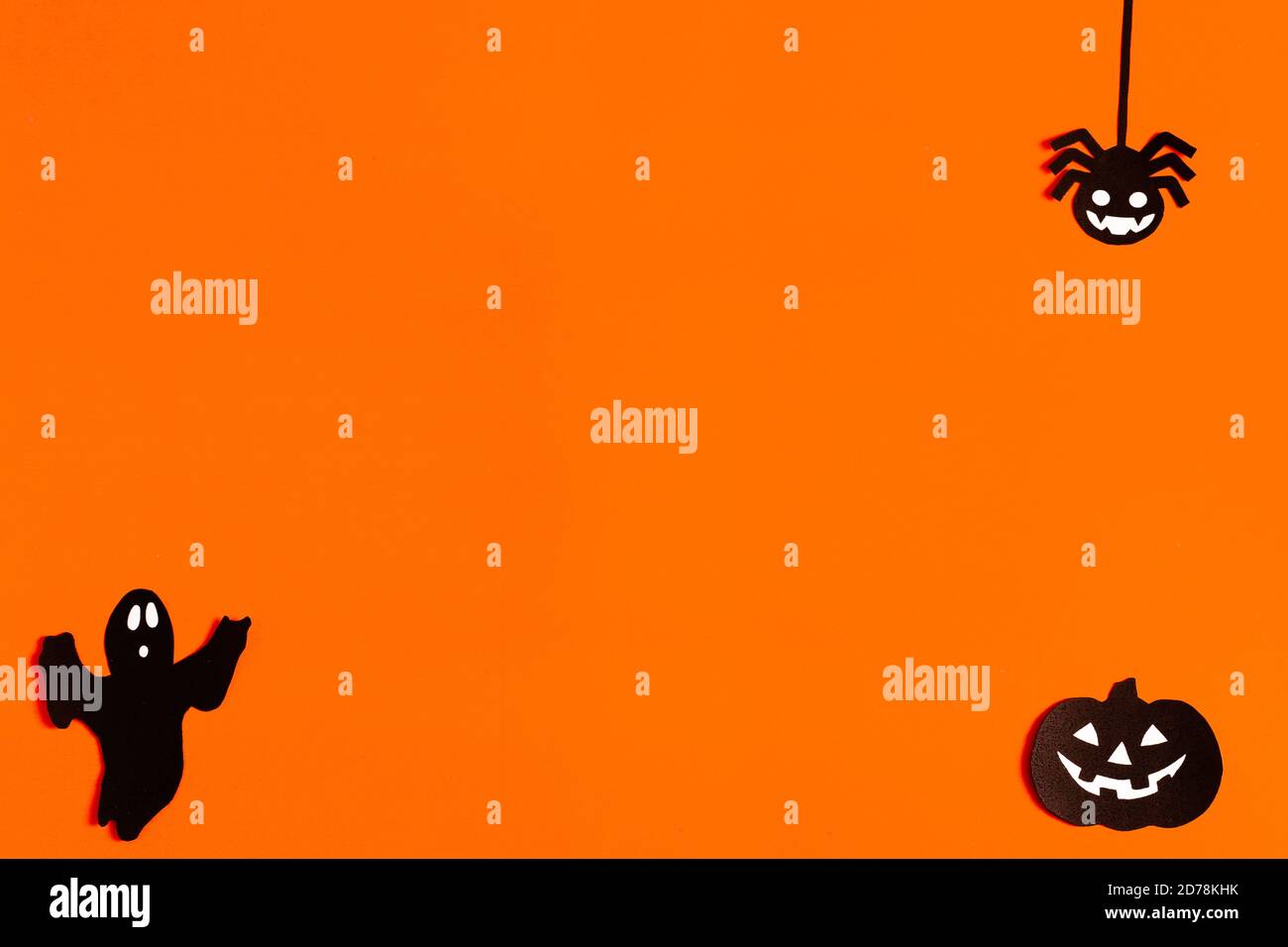 Silhouetten eines Geistes, einer Spinne und eines Kürbisses aus schwarzem Papier auf orangefarbenem Hintergrund, Halloween-Konzept, fertig gemachtes Layout mit Platz für Text, Kopie Stockfoto