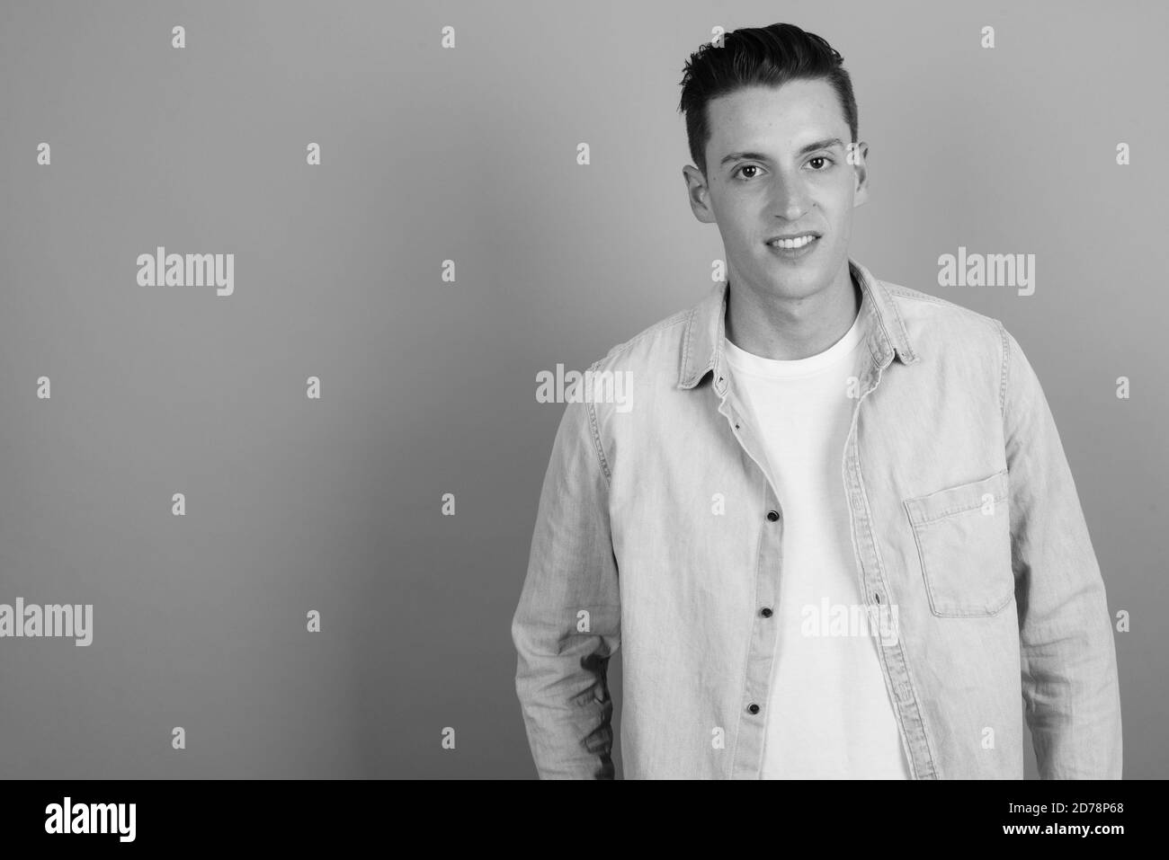 Junger schöner Mann vor grauem Hintergrund Stockfoto