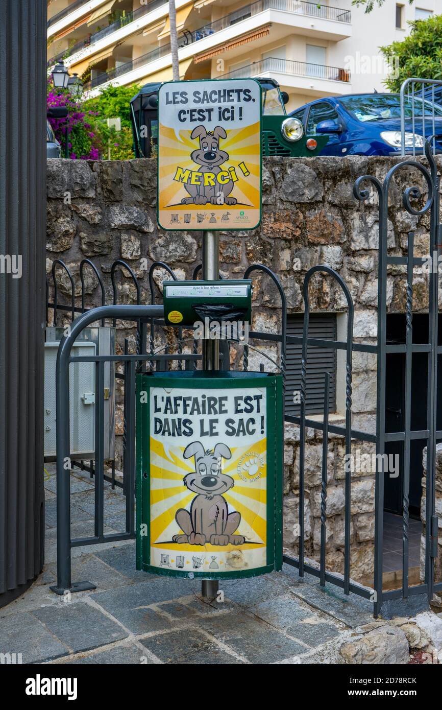 Beaulieu -sur-mer, Frankreich 14.07.2020 EIN öffentlicher Hundewaschenspender in einem Vorstadtpark mit dem Text "die Taschen sind hier, die Taille in der Tasche" und einer verschwommenen Ansicht einiger Häuser als Hintergrund. Stockfoto