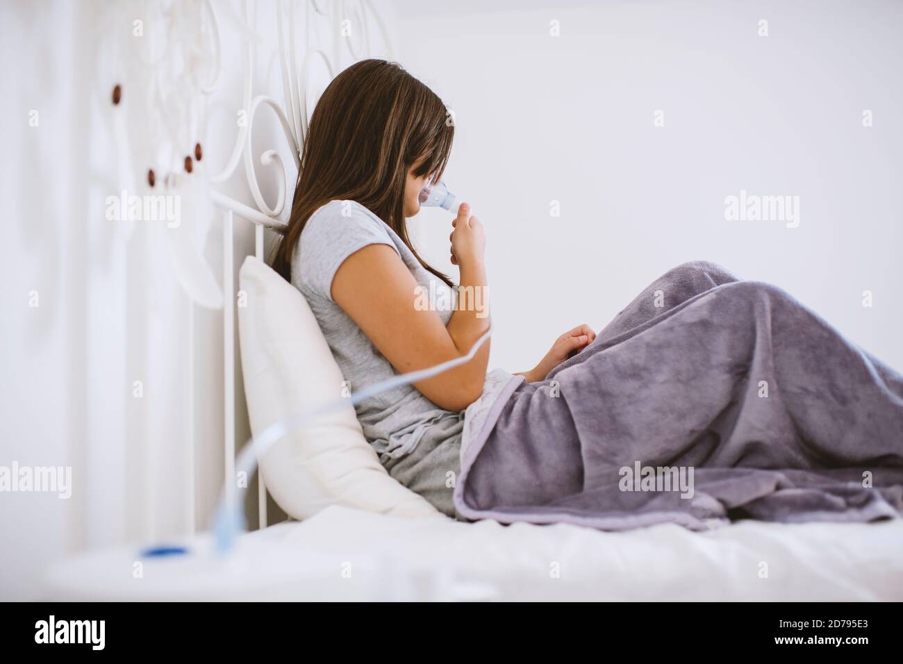 Aukasianisches Mädchen mit Maske zum Einatmen. Prävention von Bronchitis, Inhalation zu Hause. Stockfoto