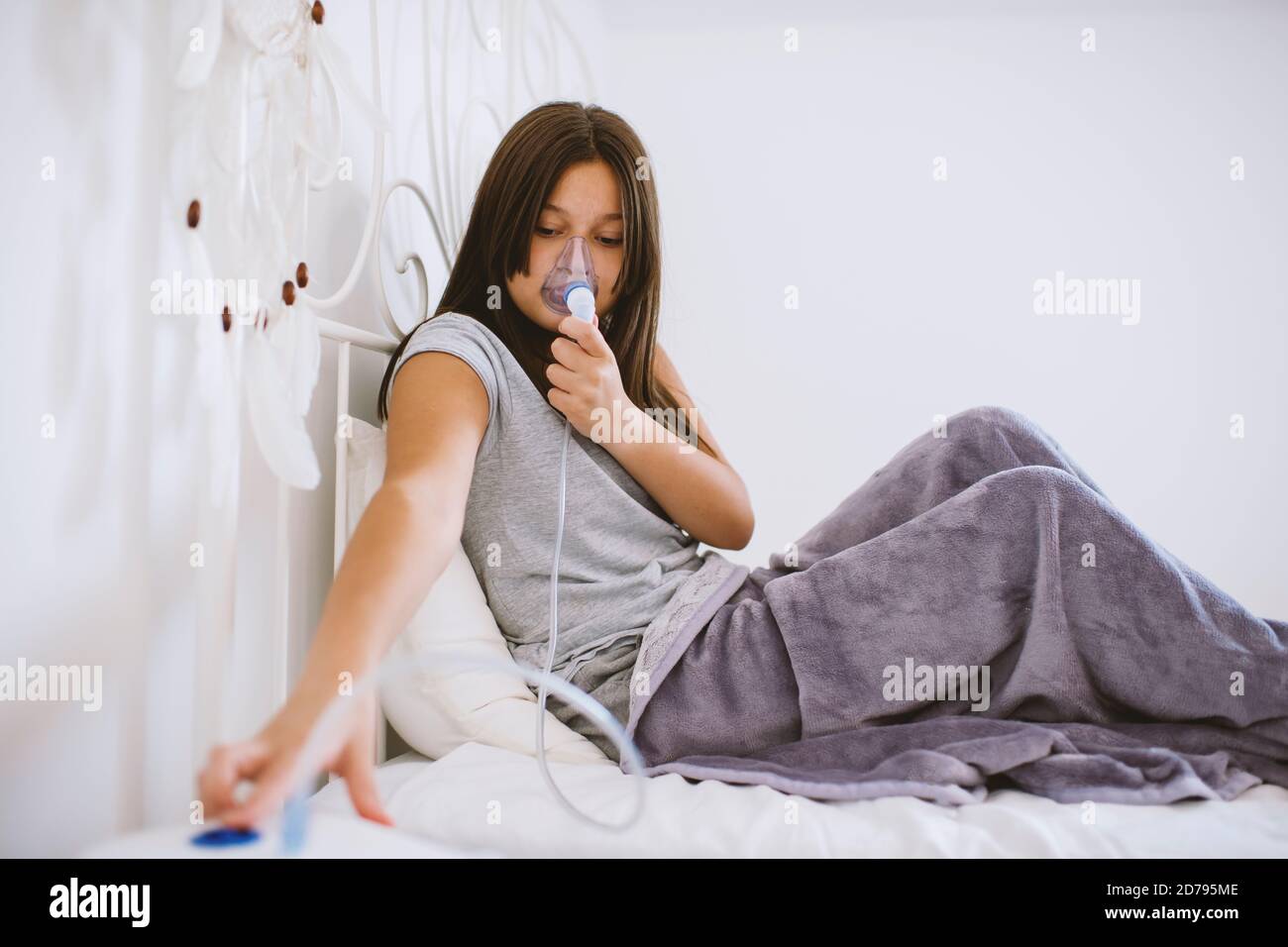 Aukasianisches Mädchen mit Maske zum Einatmen. Prävention von Bronchitis, Inhalation zu Hause. Stockfoto