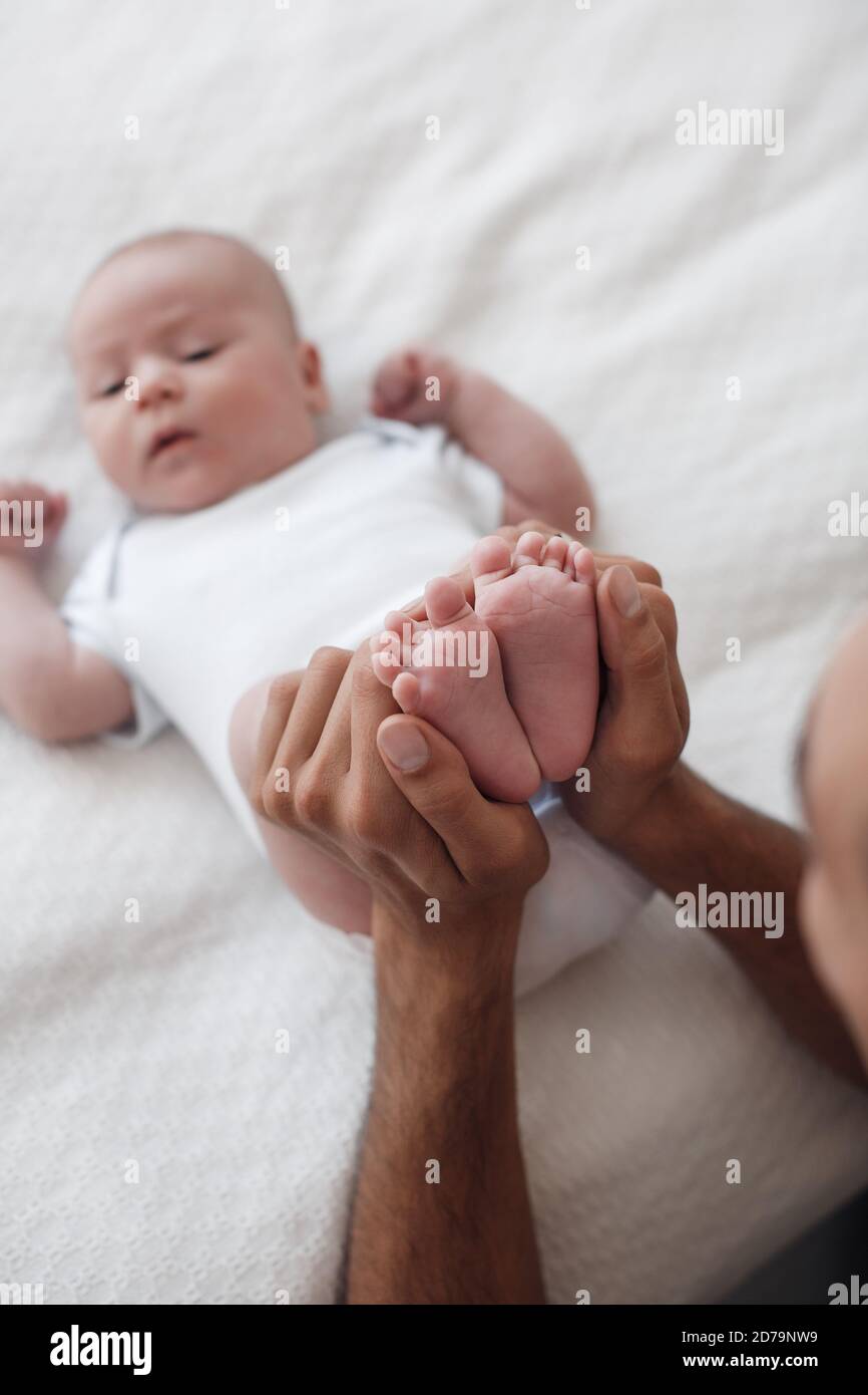 Mann mit Kleinkind. Glückliche Familie zu Hause. Glücklicher Vater mit niedlichen zwei Monate Baby Junge lag im hellen Bett zu Hause Stockfoto