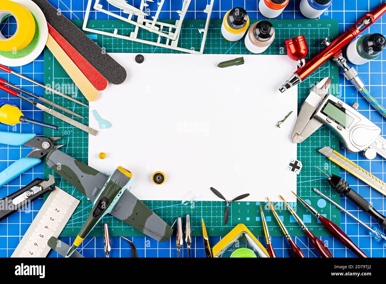 Desktop-Ansicht von oben der Montage Malerei der retro Maßstab Modell Ebene Konzept kopieren Raum Hintergrund. Modellierung Werkzeuge Airbrush Pistole Lack Kit Teile blu Stockfoto