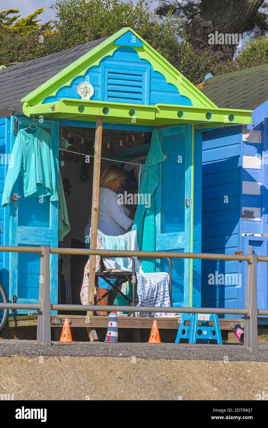 Dame macht Tee in EINEM bunten grünen und blauen Strand Hut am Avon Beach Christchurch Großbritannien Stockfoto