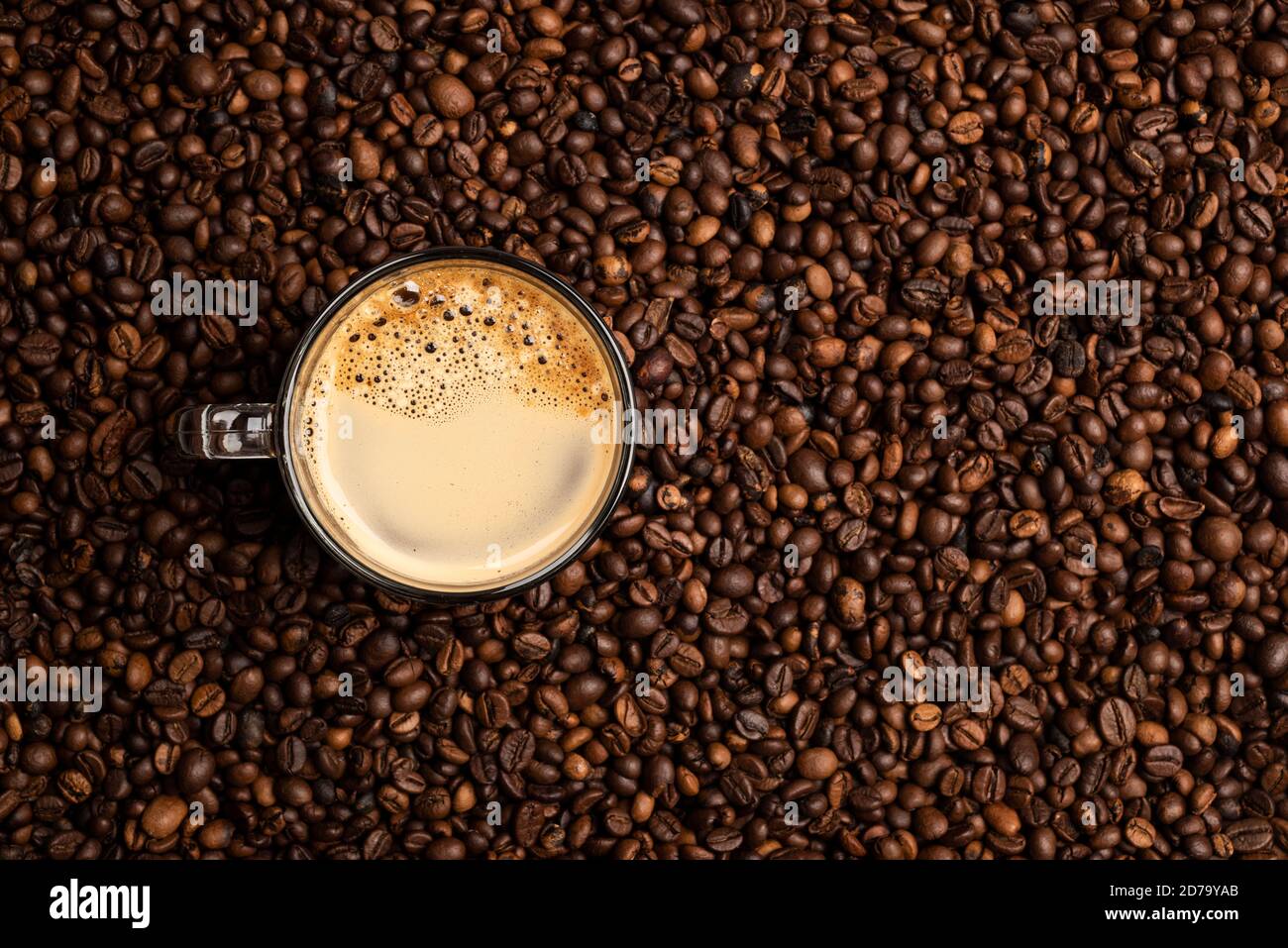 Glas Tasse voller Kaffee über einem Hintergrund von Kaffee Bohnen Stockfoto