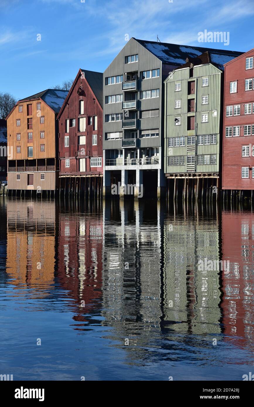 Bunte Gebäude (hölzerne Kais) spiegeln sich in der Nidelva Fluss, der durch die historische Gegend als Bakklandet, Trondheim, Norwegen, Europa bekannt fließt. Stockfoto