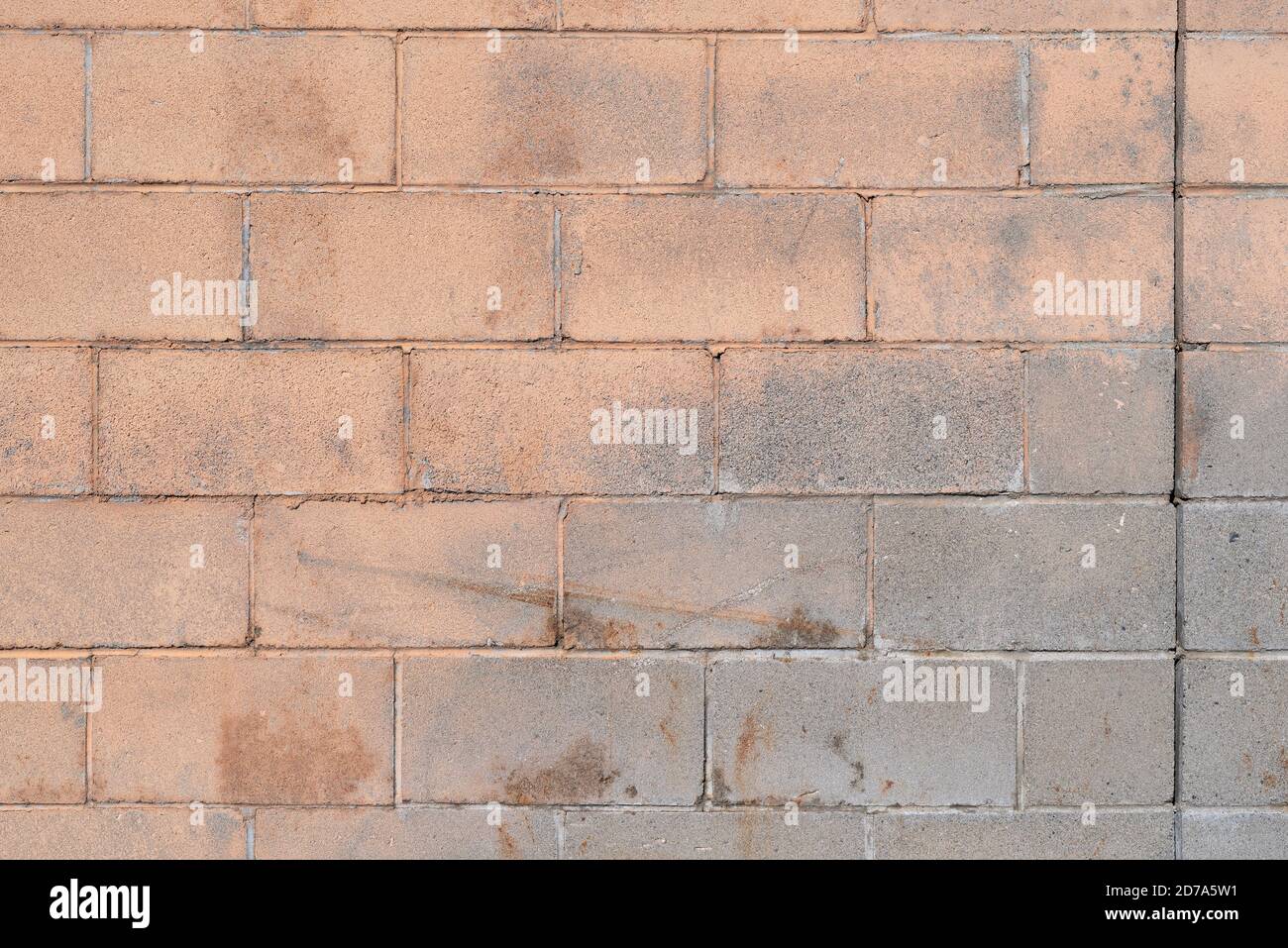 Dehnfuge in einem schmutzigen Mauerwerk Wandblöcke mit abblätternder beigefarbener Farbe und Kratzern vom Alter im frühen Morgenlicht. Stockfoto