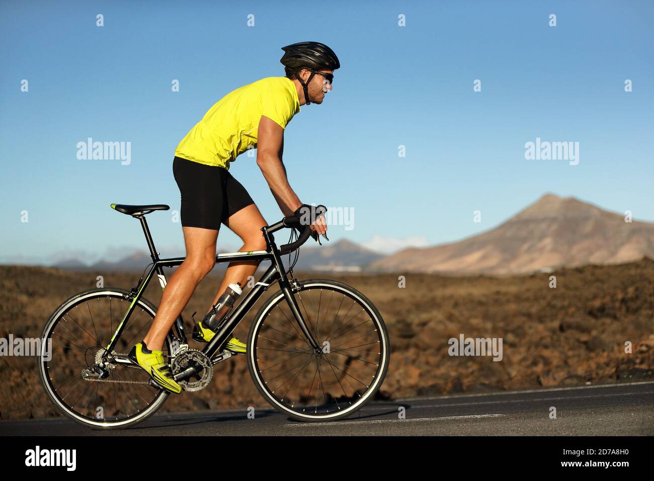 Radfahren Radfahrer männlichen Athleten gehen bergauf auf auf offener Straße Training hart auf dem Fahrrad im Freien bei Sonnenuntergang. Naturlandschaft. Stockfoto