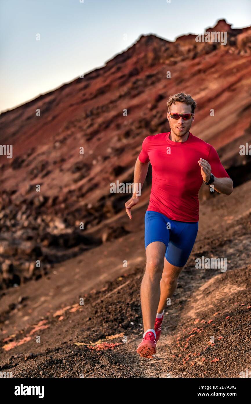 Ausdauertraining Fitness-Mann auf dem Trail laufen draußen. Athlet Läufer in Sportswear Sonnenbrillen, Kompressionskleidung, Smart Watch. Stockfoto