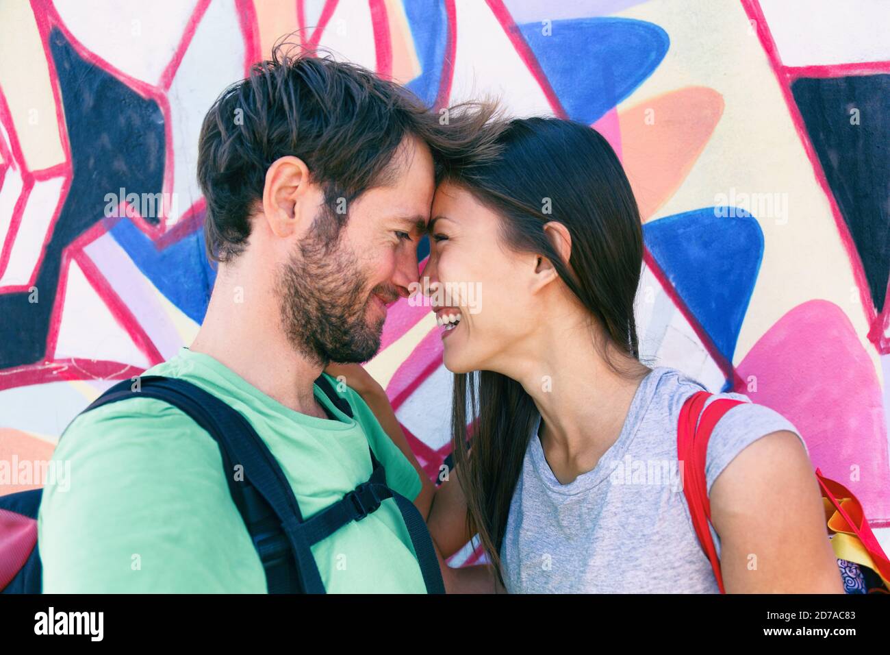 Glückliches Paar in der Liebe unter einem Selfie dabei lustig küssen Pose an berühmten Touristenattraktion Berlin Wall, Deutschland, Europa Reiseziel. Lachend Stockfoto