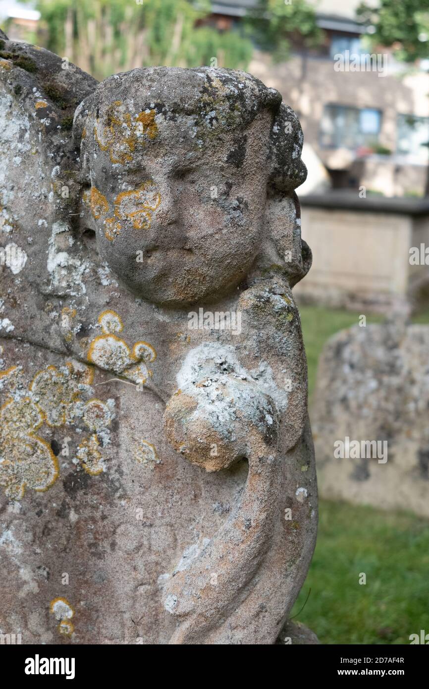 Alte Schnitzerei des Gesichts auf Grabstein an der St Andrews Kirche Chesterton Cambridge, Großbritannien Stockfoto