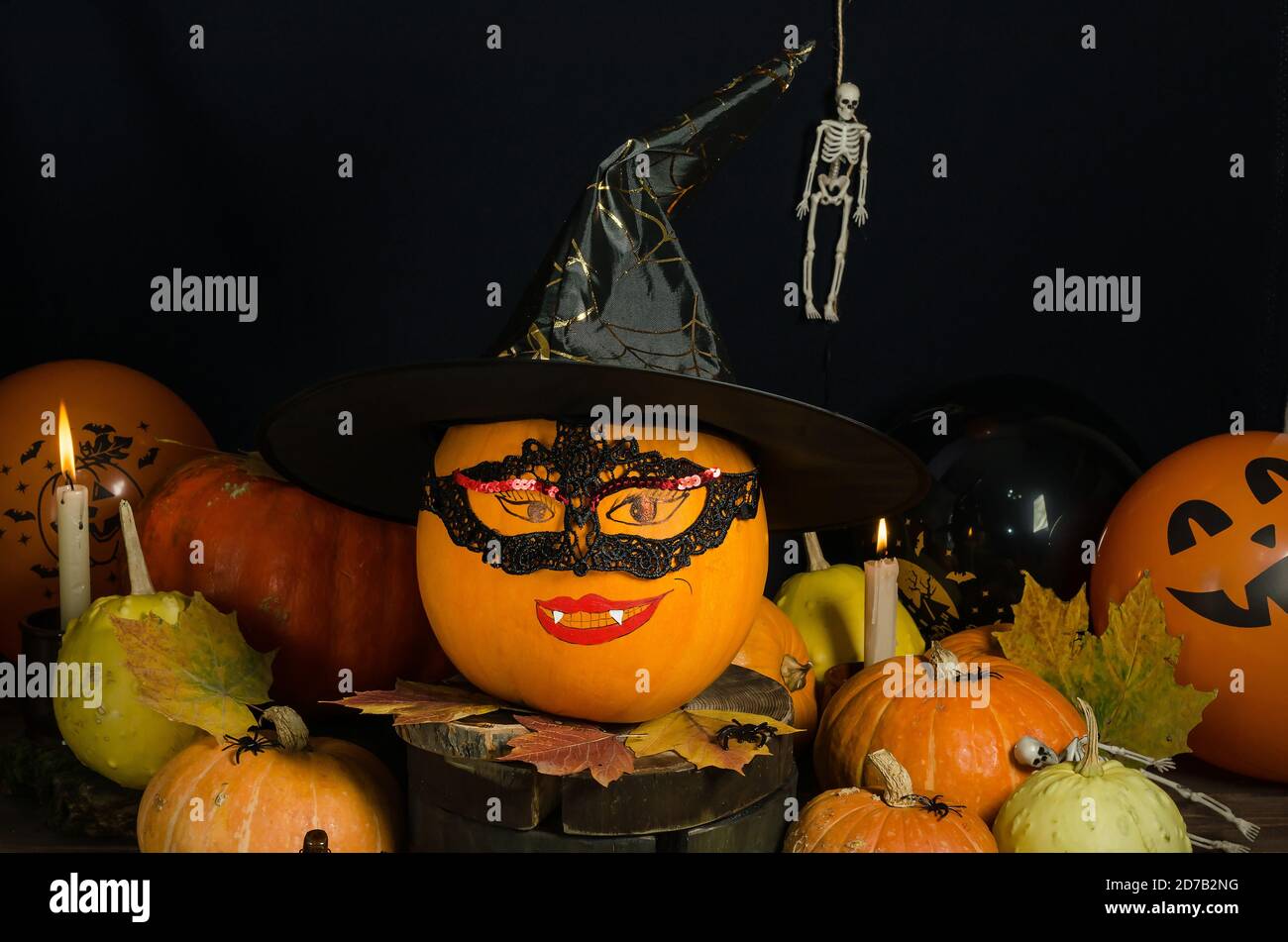 Halloween Hintergrund, Kürbis mit gemaltem Gesicht in Maske und Hexenhut auf schwarzem Hintergrund. Halloween Home Dekorieren Idee Stockfoto