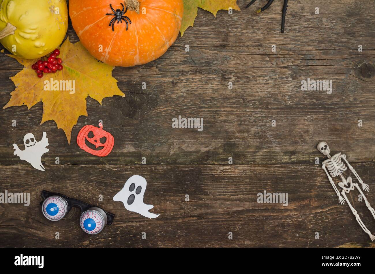 Halloween Postkartenhintergrund, Kürbisse und Geister auf einem alten Holzhintergrund mit Kopierraum. Stockfoto