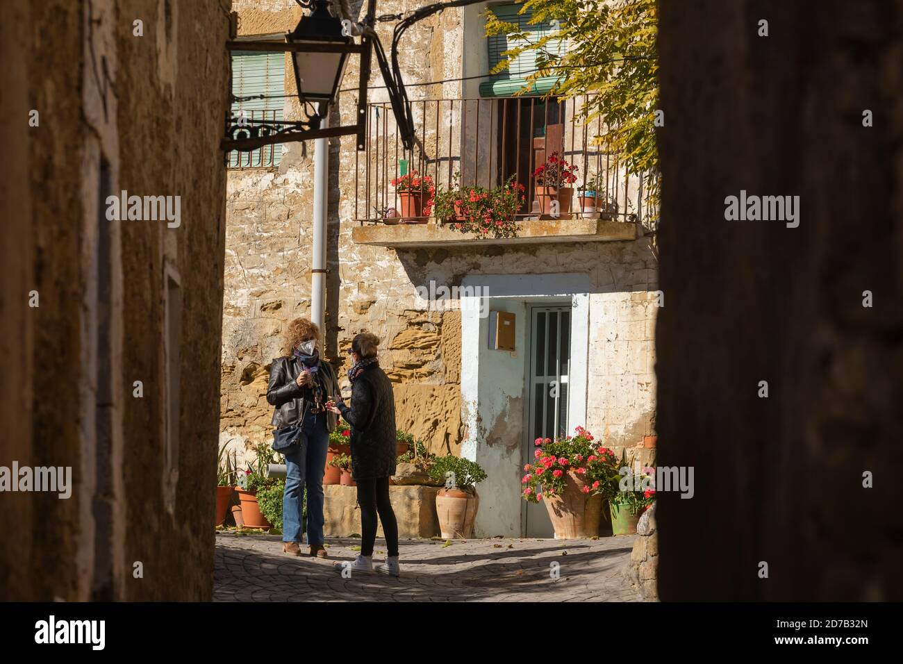 Ein paar Frauen, Nachbarn, plaudern in einer der Straßen der kleinen Stadt Erz, Aragon, Spanien. Stockfoto