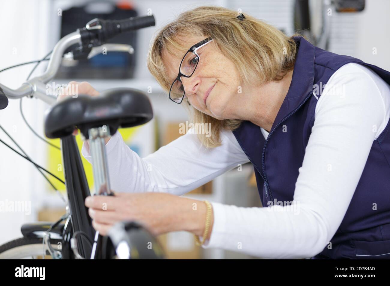 Reife Frau Reparatur ein Fahrrad in der Werkstatt Stockfoto